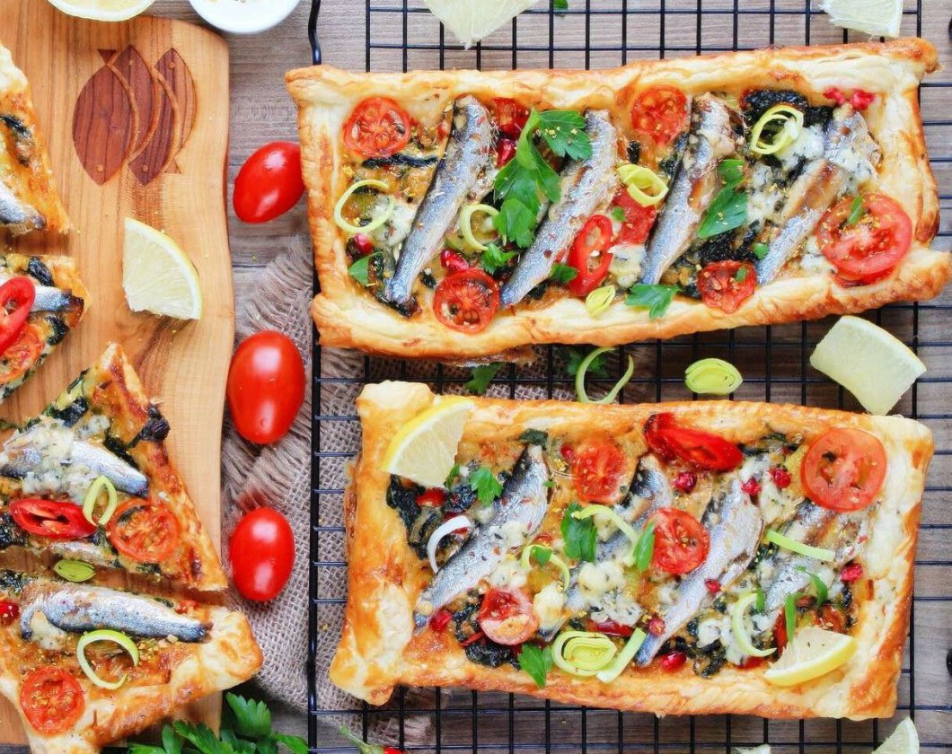 Mini-Blätterteigkuchen mit Lauch, Spinat, Sprotten und Tomaten